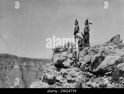 Regarder le signal, c1905. Trois Indiens Crow, un assis, deux debout, face à gauche. Banque D'Images