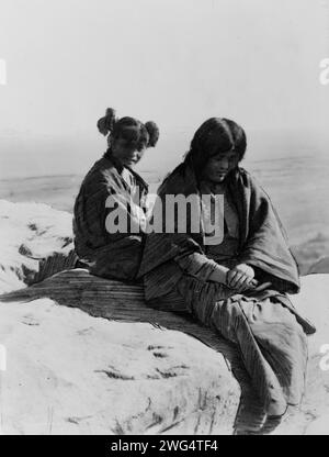 Maiden et Matron, c1905. Deux femelles Hopi assises sur un rocher. Banque D'Images