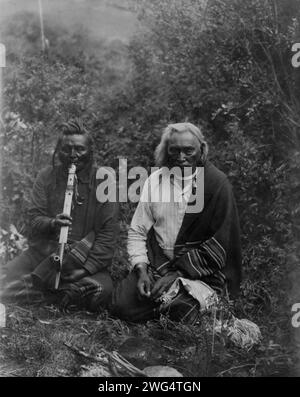 Une fumée, c1905. Deux Indiens Crow dans le Montana, assis par terre, l'un fume une pipe. Banque D'Images