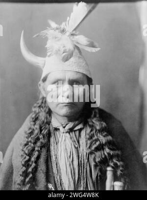 Oyegi-a YE ("Frost Moving"), gouverneur de Santa Clara, c1905. Oyegi-a YE, portrait tête et épaules, face à l'avant, coiffé d'une casquette avec plumes et une seule corne. Banque D'Images