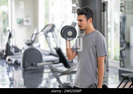 Un homme en contemplation, se préparant à soulever des poids. Cette image capture le moment de la préparation mentale dans le sport et le fitness.préparation mentale pour p Banque D'Images