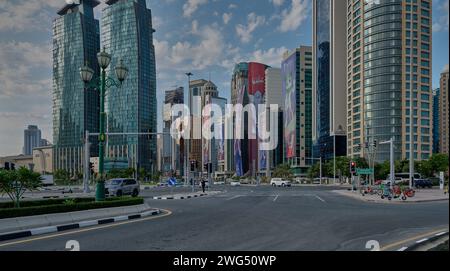 Horizon de Doha dans le quartier West Bay Doha, Qatar après-midi tourné avec les mascottes de la Coupe d'Asie de l'AFC Qatar 2023 sur les bâtiments et les nuages dans le ciel Banque D'Images