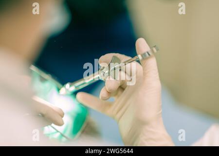 Détail d'un dentiste pratiquant une chirurgie avec anesthésie sur un patient pour traitement canalaire et régénération. Personne n'est reconnaissable. Banque D'Images