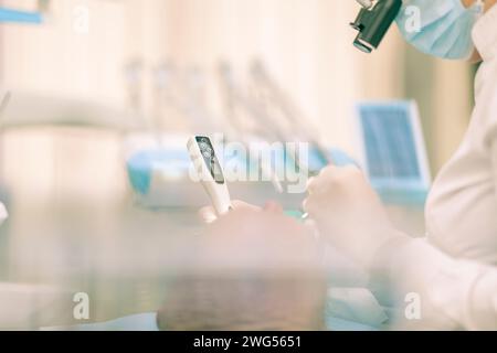 Détail d'un dentiste pratiquant une chirurgie avec anesthésie sur un patient pour traitement canalaire et régénération. Personne n'est reconnaissable. Banque D'Images