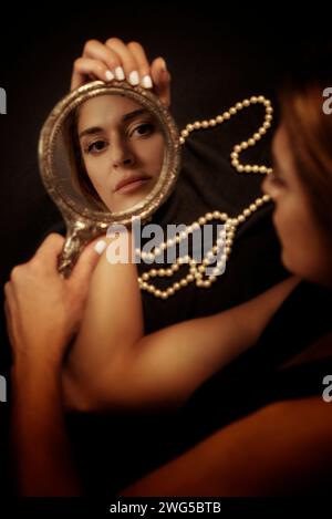 Femme tenant un miroir à main Banque D'Images