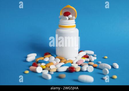 Gros plan, pilules éparpillées sur la table. Beaucoup de pilules de différentes couleurs et formes. Antipyrétiques, analgésiques et antibiotiques. Fond avec copie spa Banque D'Images
