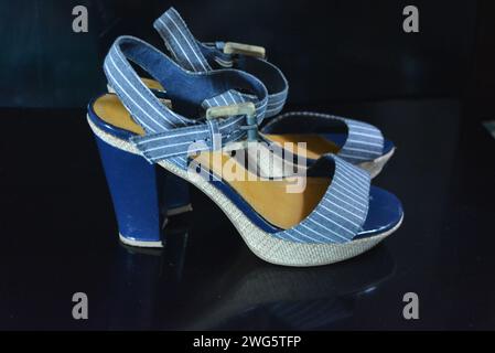 Chaussures femme élégantes et inhabituelles en cuir verni bleu véritable et tissu bleu. Sandales, sandales, chaussures de vol sont situés sur un noir brillant. Banque D'Images