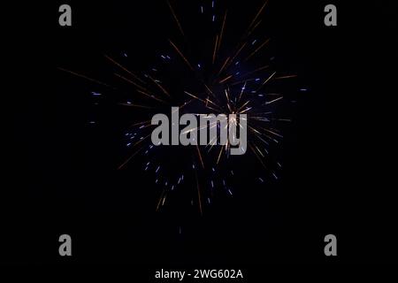 Éclatement de feux d'artifice bleus et orange la nuit - stries vibrantes et étincelles - nuages de fumée - célébration, jour de l'an, 4 juillet, fête du canada. Prenez Banque D'Images