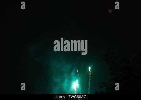 Éclatement de feux d'artifice verts sur le point d'exploser la nuit - stries vertes vibrantes et étincelles - nuages de fumée - célébration, jour du nouvel an, le 4 juillet Banque D'Images