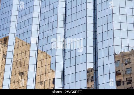 Réflexions sur un immeuble de verre de grande hauteur dans la ville Banque D'Images