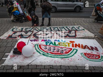 Un enfant écrit un message sur une pancarte lors d'une marche pro-palestinienne à Londres appelant à un cessez-le-feu immédiat. Banque D'Images