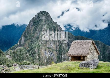 La cabane de chaume en pierre sèche de la Maison des Gardiens se dresse en face de la montagne Huayna Picchu au Machu Picchu. Banque D'Images