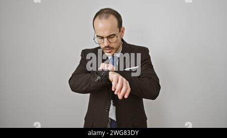 Homme d'affaires hispanique vérifie le temps sur montre-bracelet sur fond blanc isolé Banque D'Images