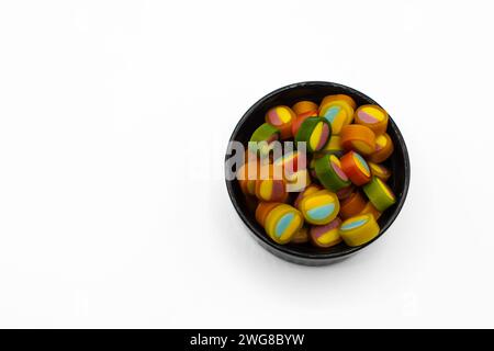 Bonbons gélifiés multicolores dans un bol sur un fond blanc Banque D'Images