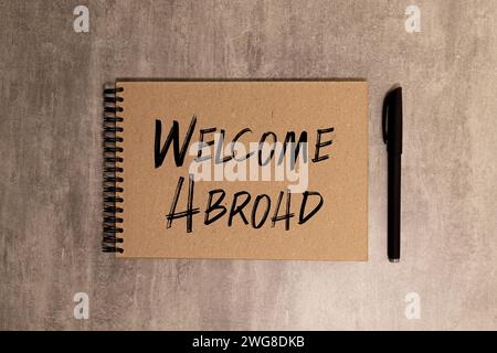TRAVAILLER À L'ÉTRANGER texte écrit sur papier jaune avec cahier. Banque D'Images