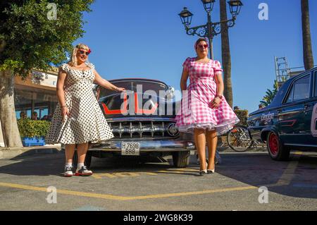 Deux femmes habillées dans le style des années cinquante posant devant une vieille voiture classique au Rockin Race Jamboree festival 2024, rockabillies, Torremolinos, Espagne. Banque D'Images