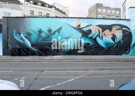 Grande murale de Spray.Saint, inspirée par le mythe de la sirène de mer ; de belles femmes qui vivaient sous l'eau chantaient aux marins les attirant à leur mort, juillet 2023. Banque D'Images