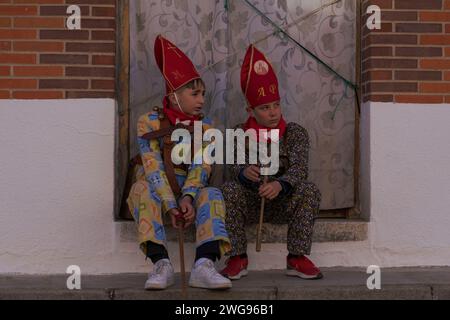 Almonacid de Marquesado, Cuenca, Espagne. 3 février 2024. Deux jeunes membres de la confrérie Endiablada se réunissent lors de la fête traditionnelle Endiablada à Almonacid Del Marquesado, Espagne. Chaque année, du 2 au 3 février, la ville d'Almonacid del Marquesado dans le centre de l'Espagne accueille les festivités animées ''Endiablada'' (la Fraternité des Diables), une tradition datant de l'époque médiévale ou plus tôt en l'honneur de la Candelaria et San Blas. Au cours de cet événement animé, les participants masculins arborent une tenue diabolique, notamment des costumes de combinaison éclatants et des chapeaux d'onglet rouges. Crédit : ZUMA Press, Inc./Alamy Live News Banque D'Images