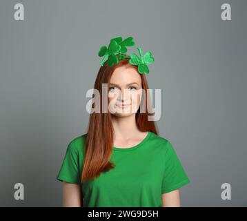 Prog Fête de Patrick. Jolie femme avec bandeau de trèfle vert sur fond gris Banque D'Images