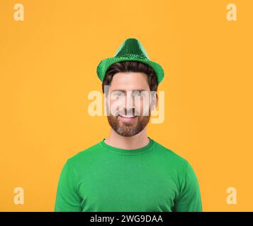 Prog Fête de Patrick. Homme en chapeau de leprechaun vert sur fond doré Banque D'Images