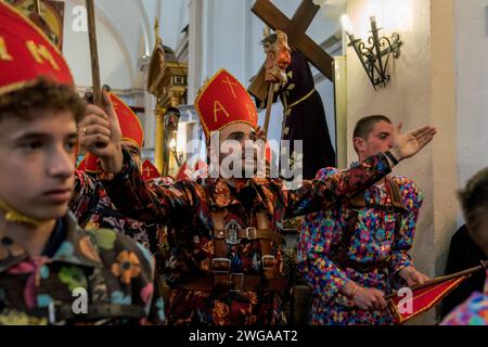 Les membres de la confrérie Endiablada dansent pendant le festival traditionnel Endiablada. Chaque année, du 2 au 3 février, la ville d'Almonacid del Marquesado dans le centre de l'Espagne accueille les festivités animées 'Endiablada' (la Fraternité des Diables), une tradition datant de l'époque médiévale ou plus tôt en l'honneur de la Candelaria et San Blas. Au cours de cet événement animé, les participants masculins arborent une tenue diabolique, notamment des costumes de combinaison éclatants et des chapeaux d'onglet rouges. Ornés de cloches de cuivre de taille importante autour de leur taille, les festivités se déroulent alors qu'ils traversent les rues sinueuses de la ville, s'engageant dans dan Banque D'Images