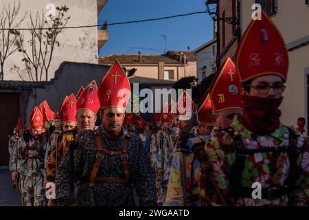 Les membres de la confrérie Endiablada défilent pendant la fête traditionnelle Endiablada. Chaque année, du 2 au 3 février, la ville d'Almonacid del Marquesado dans le centre de l'Espagne accueille les festivités animées 'Endiablada' (la Fraternité des Diables), une tradition datant de l'époque médiévale ou plus tôt en l'honneur de la Candelaria et San Blas. Au cours de cet événement animé, les participants masculins arborent une tenue diabolique, notamment des costumes de combinaison éclatants et des chapeaux d'onglet rouges. Ornés de cloches de cuivre de taille importante autour de leur taille, les festivités se déroulent alors qu'ils traversent les rues sinueuses de la ville, s'engageant dans dan Banque D'Images