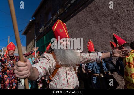 Les membres de la confrérie Endiablada dansent pendant le festival traditionnel Endiablada. Chaque année, du 2 au 3 février, la ville d'Almonacid del Marquesado dans le centre de l'Espagne accueille les festivités animées 'Endiablada' (la Fraternité des Diables), une tradition datant de l'époque médiévale ou plus tôt en l'honneur de la Candelaria et San Blas. Au cours de cet événement animé, les participants masculins arborent une tenue diabolique, notamment des costumes de combinaison éclatants et des chapeaux d'onglet rouges. Ornés de cloches de cuivre de taille importante autour de leur taille, les festivités se déroulent alors qu'ils traversent les rues sinueuses de la ville, s'engageant dans dan Banque D'Images