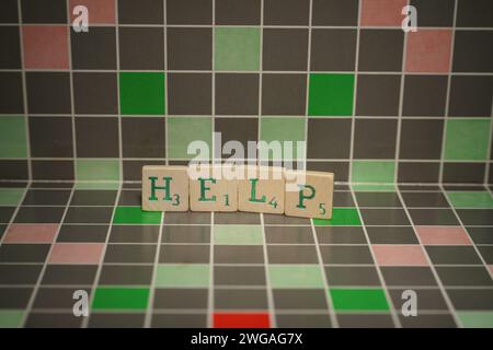 Tuile en bois avec texte d'aide vert sur un fond bloqué Banque D'Images