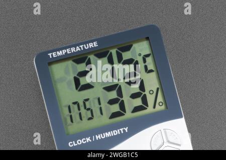 Thermomètre et hygromètre numérique intérieur moderne avec horloge. Gros plan sur fond gris, isolé Banque D'Images