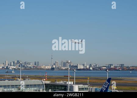 Tokyo, Japon – 20 novembre 2023 : avion de Japan Airlines décollant de l'aéroport de Tokyo Haneda avec le Tokyo Skytree et les gratte-ciel en arrière-plan. Banque D'Images