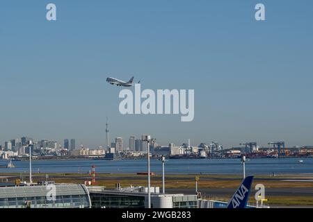 Tokyo, Japon – 20 novembre 2023 : avion de Japan Airlines décollant de l'aéroport de Tokyo Haneda avec le Tokyo Skytree et les gratte-ciel en arrière-plan. Banque D'Images