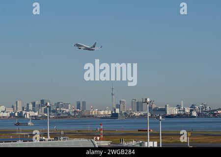 Tokyo, Japon – 20 novembre 2023 : avion de Japan Airlines décollant de l'aéroport de Tokyo Haneda avec le Tokyo Skytree et les gratte-ciel en arrière-plan. Banque D'Images