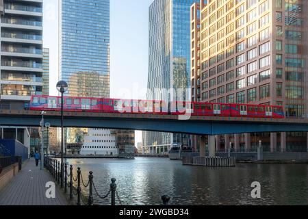 Train DLR Docklands Light Railway passant sur le pont à travers South Dock avec les gratte-ciel Canary Wharf, East London, Angleterre, Royaume-Uni Banque D'Images