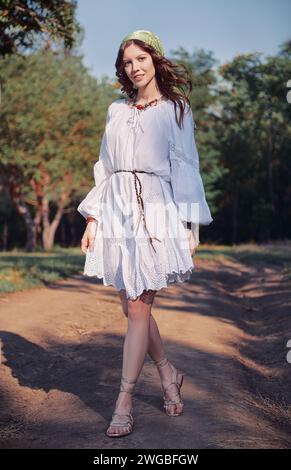 Mode de plein air : la belle jeune fille boho (hippie) dans bosquet (forêt). Portrait de belle fille hippie souriante sur la route Banque D'Images