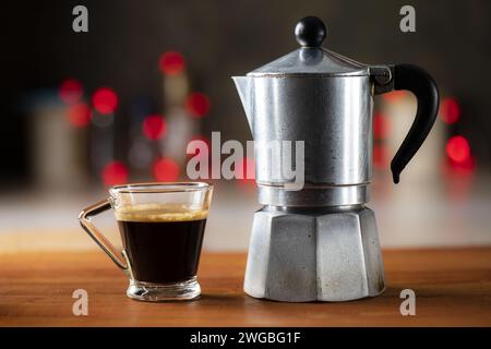 Au premier plan un vieux moka italien et une tasse de café chaud. en arrière-plan un effet bokeh agréable Banque D'Images