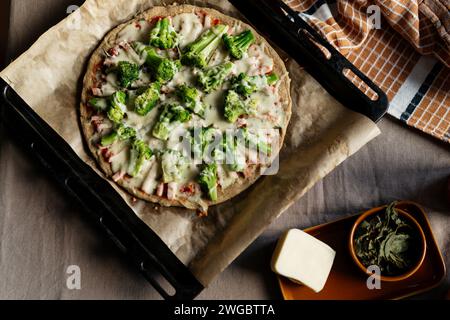 Vue aérienne d'une pizza maison à faible teneur en glucides et à la farine d'amande céto avec brocoli, jambon et fromage Banque D'Images