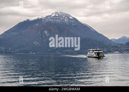 Ferry bateau naviguant à travers le lac de Côme avec toile de fond de montagne, Varenna, Lombardie, Italie Banque D'Images