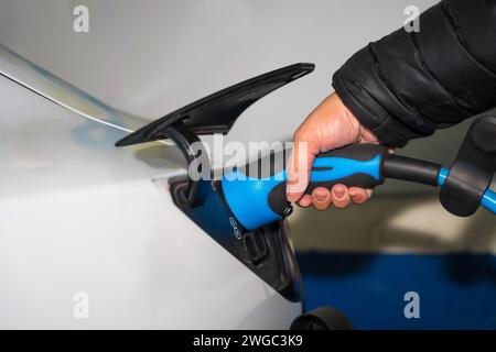 Détail de la main d'un homme avec le chargeur de voiture électrique Banque D'Images