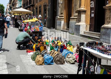 Palerme, Italie - 13 mai 2023 : vendeur à son étal vendant des sacs, des sacs à main, des vêtements et des lunettes de soleil dans une rue commerçante via Maqueda à Palerme, Sicile, I Banque D'Images