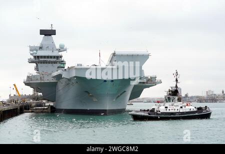 Le porte-avions de la Royal Navy HMS Queen Elizabeth à côté de HMNB Portsmouth. Le départ du HMS Queen Elizabeth pour diriger le plus grand exercice de l'OTAN depuis la guerre froide a été annulé à la dernière minute après qu'un "problème" avec un arbre de transmission ait été repéré lors des vérifications finales. Le revers survient 18 mois après que le navire jumeau HMS Prince of Wales est tombé en panne au large de l'île de Wight après avoir navigué pour les États-Unis après avoir subi un dysfonctionnement avec un accouplement sur son hélice tribord.Date de l'image : dimanche 4 février 2024. Banque D'Images