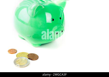 Tirelire avec des pièces de monnaie surlignées sur fond blanc. Banque D'Images