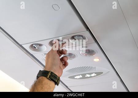 Rotation de la main du passager régler la température à partir du climatiseur de la cabine dans l'avion Banque D'Images