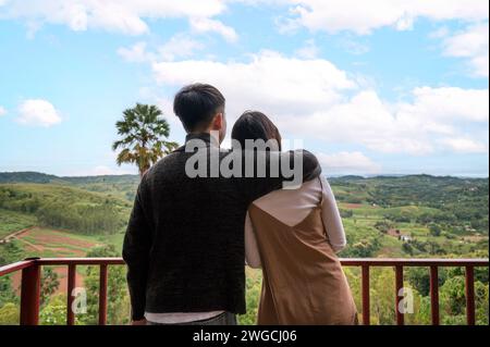 Doux jeune couple asiatique embrassant et admirant sur la colline de montagne dans la campagne pendant les vacances d'été Banque D'Images