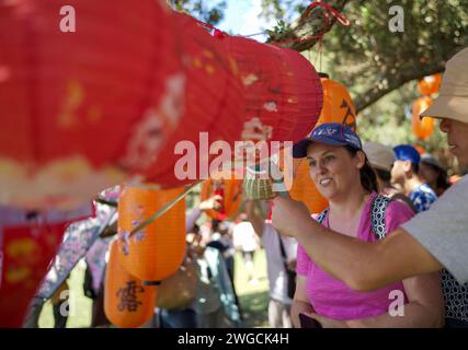 Auckland, Nouvelle-Zélande. 4 février 2024. Les gens regardent les lanternes traditionnelles chinoises au carnaval de plage « Happy Chinese New Year » à Auckland, en Nouvelle-Zélande, le 4 février 2024. Le carnaval de la plage « bonne année chinoise », co-organisé par le China Cultural Centre à Auckland et l'Asian Community engagement Trust, s'est tenu dimanche à Mission Bay Beach à Auckland. Crédit : Zhao Gang/Xinhua/Alamy Live News Banque D'Images