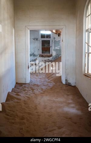 Le sable couvrant le sol d'un couloir abandonné dans une vieille ville désertique Banque D'Images