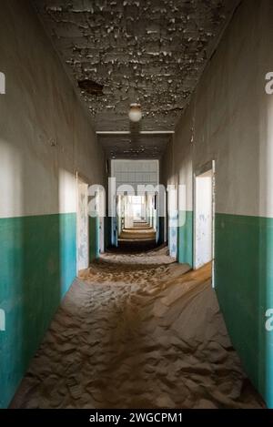 Le sable couvrant le sol d'un couloir abandonné dans une vieille ville désertique Banque D'Images