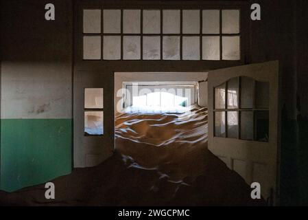 Le sable couvrant le sol d'un couloir abandonné dans une vieille ville désertique Banque D'Images