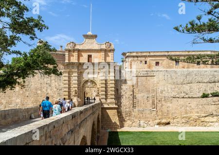 Mdina, Malte - 7 juin 2022 : touristes sur le pont menant à la porte de la ville de Mdina, également connu sous le nom de porte principale a été construit dans les années 1720 Banque D'Images