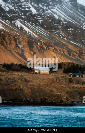 Une maison nordique typique en face des montagnes dans le sud de l'Islande Banque D'Images