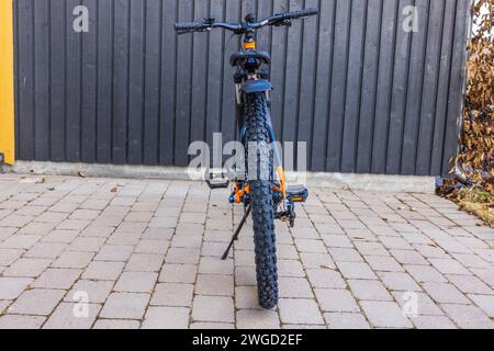 Vue rapprochée de derrière le vélo de sport de montagne garé sur le trottoir près de la maison. Suède. Banque D'Images